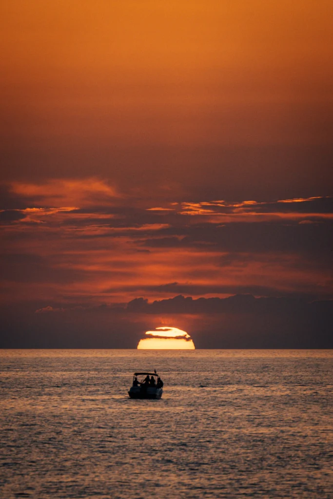 Foto del panorama dal Monkey Ibiza, con vista sul mare al tramonto. Non ci sono molte nuvole all'orizzonte e il sole è già parzialmente tramontato.